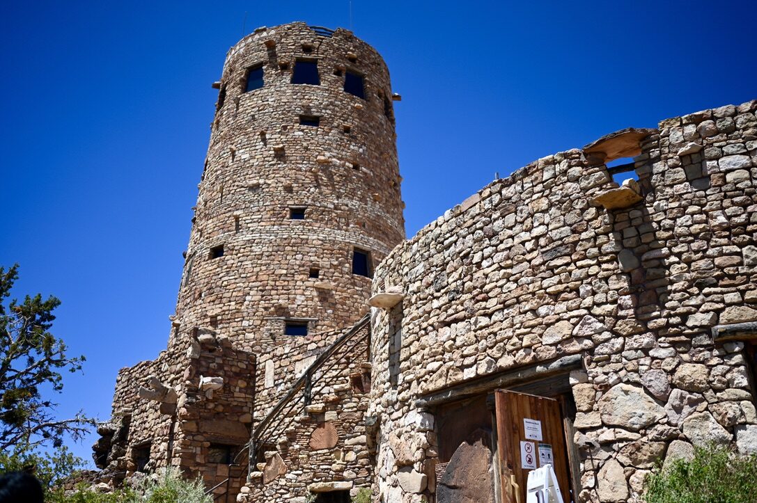 The round stone Desert View Watchtower against a deep blue sky
