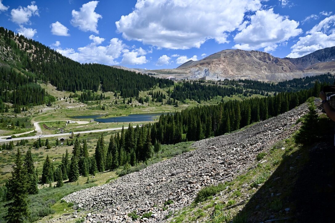 Alpine valley with pine forest, a small lake and mountains, seen from the train