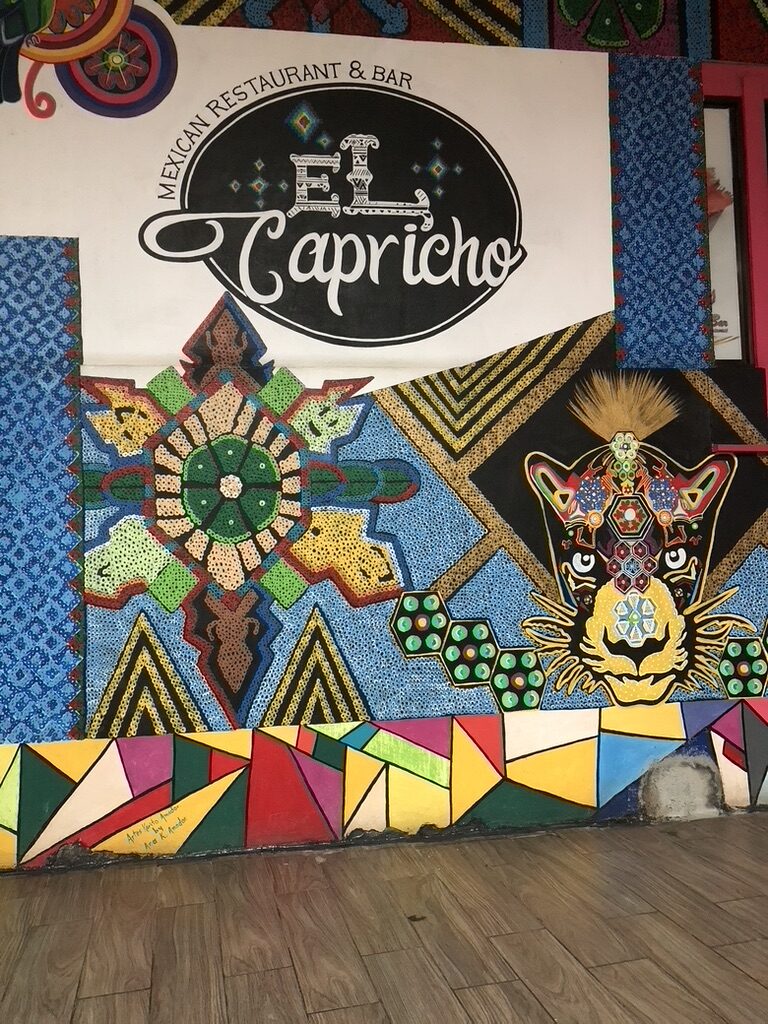 The colorful painted sign of El Capricho restaurant