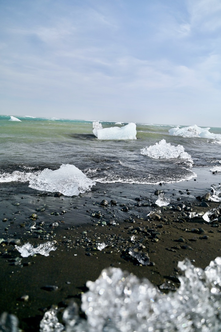 Chunks of ice from Jokulsarlon glacier and icebergs in the sea and on the beach called Diamond beach