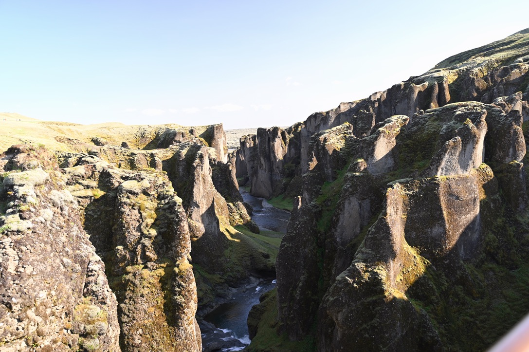 Moss covered canyon walls on two sides with a river running through