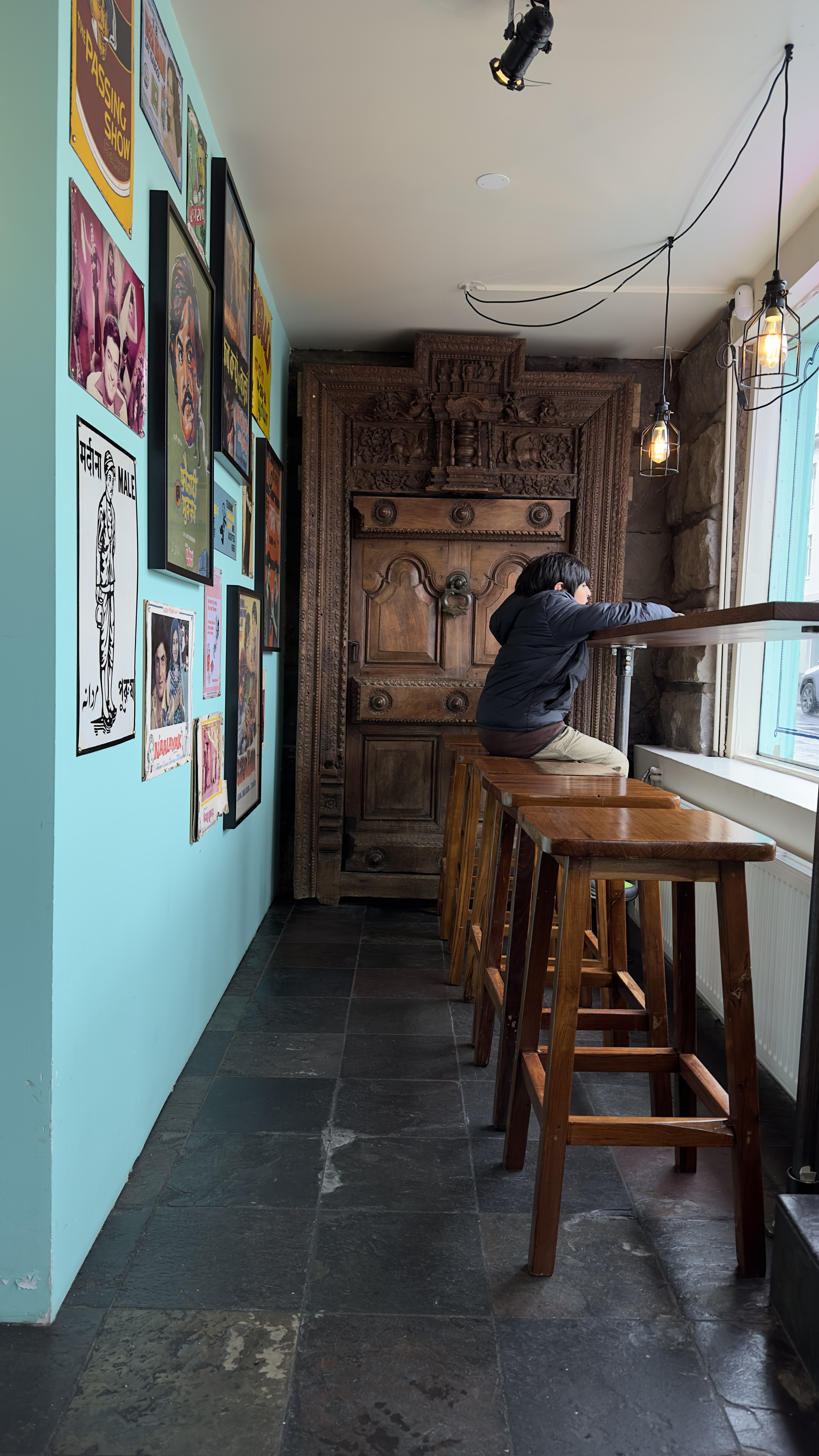 Boy sitting on a counter stool inside an Indian restaurant in Iceland