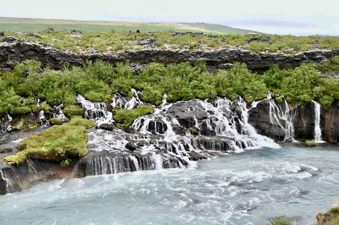 Cascading wide wall of waterfalls and a river stemming from it.