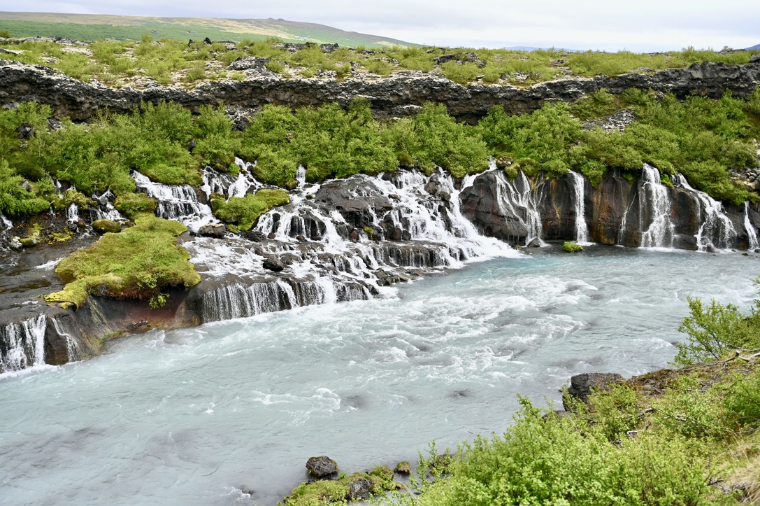 Cascading wide wall of waterfalls and a river stemming from it.