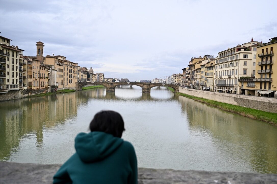 Boy looking along the Arno toward the Ponte Vecchio