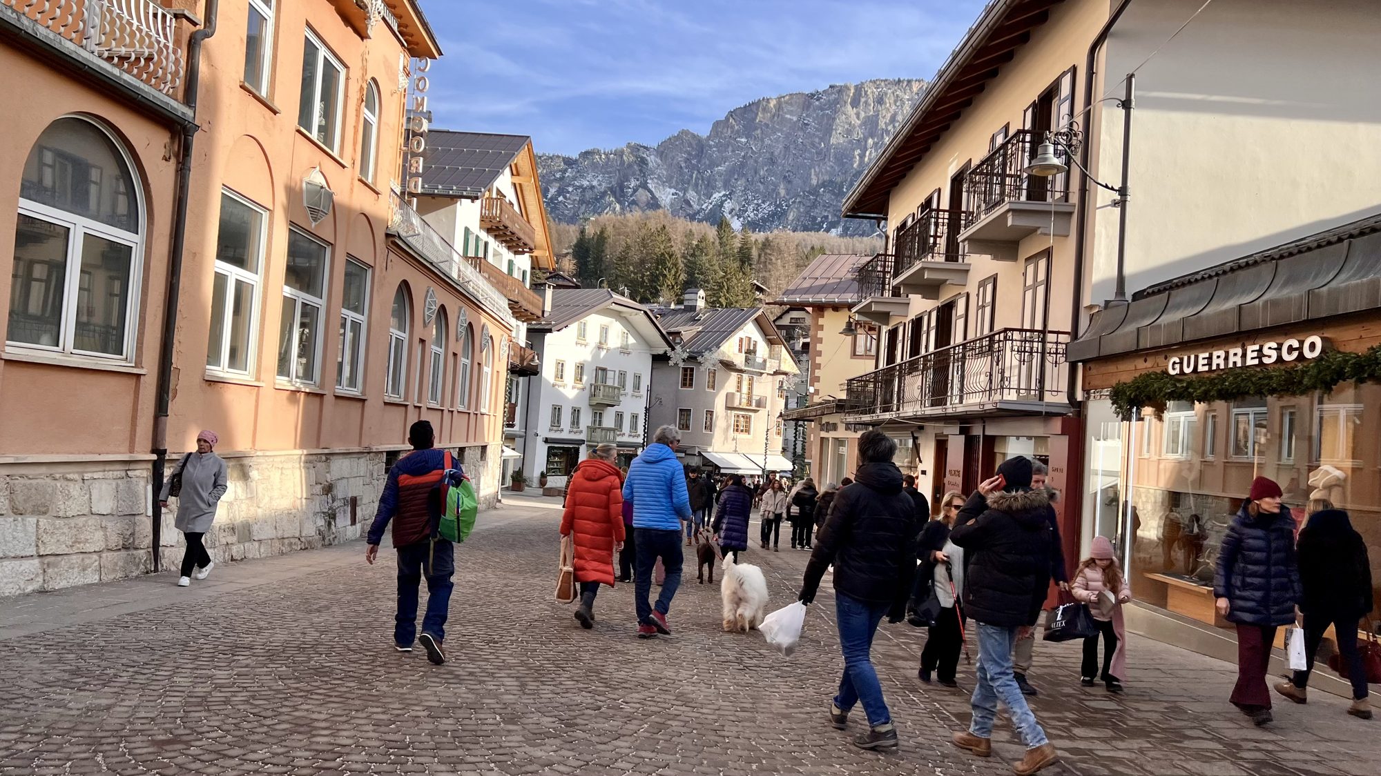 Busy pedestrian street in Cortina d’Ampezzo with mountains behind