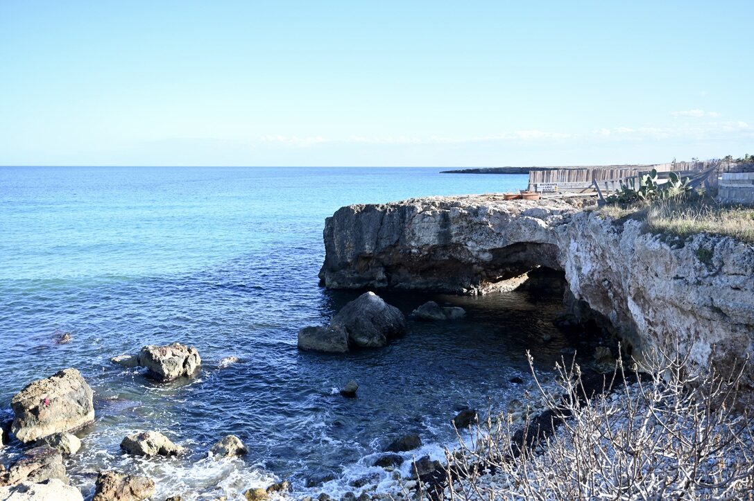 The rocky coast near Monopoli with a sea arch and blue water