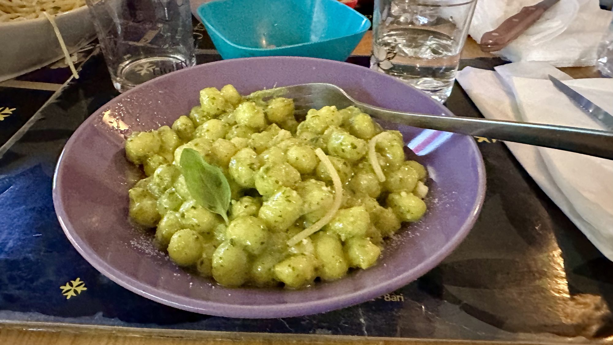 A bowl of pasta in bright green pesto