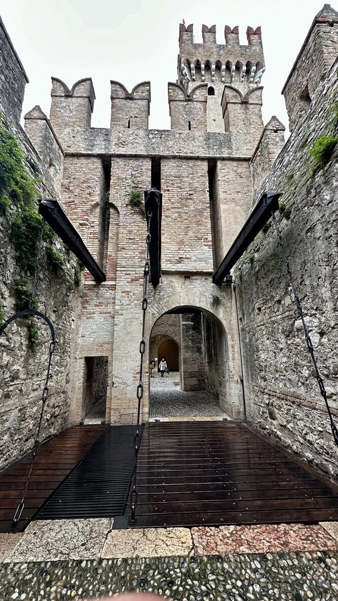 A crenellated stone tower and gateway inside Sirmione Castle