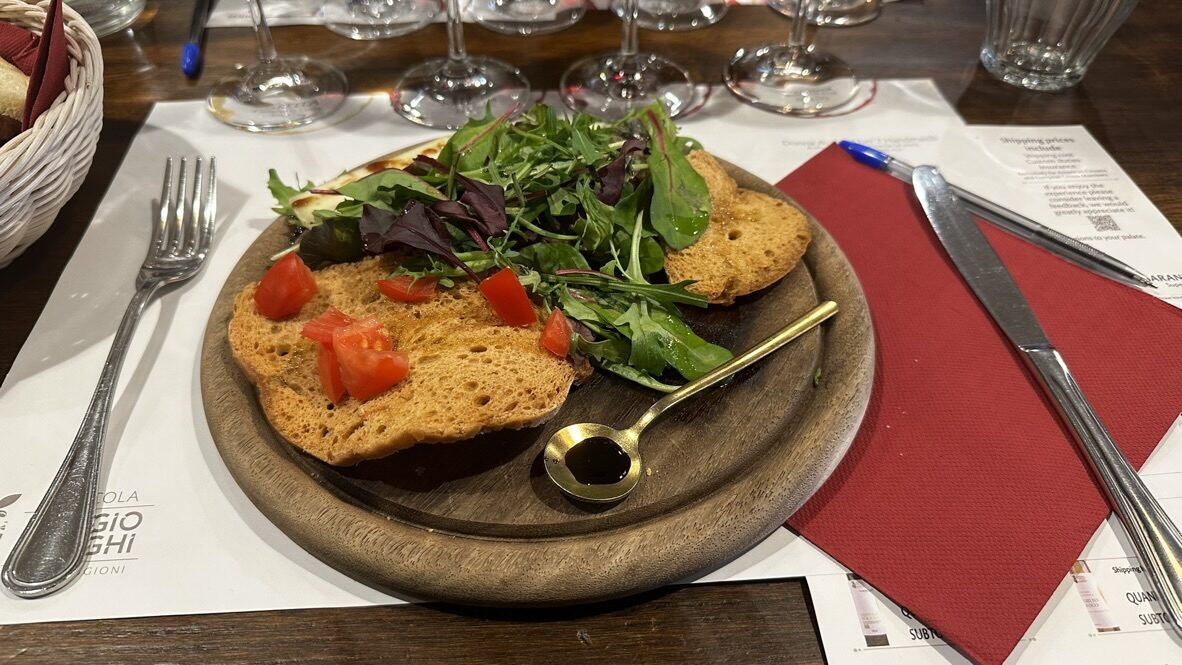 Bruschetta with tomato and arugula on a wooden board at the vineyard