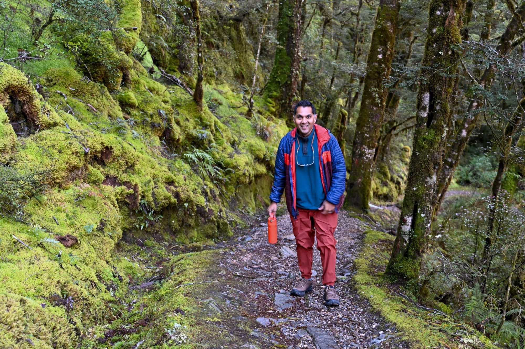 His dad smiling on a narrow trail through moss-covered banks and trees.