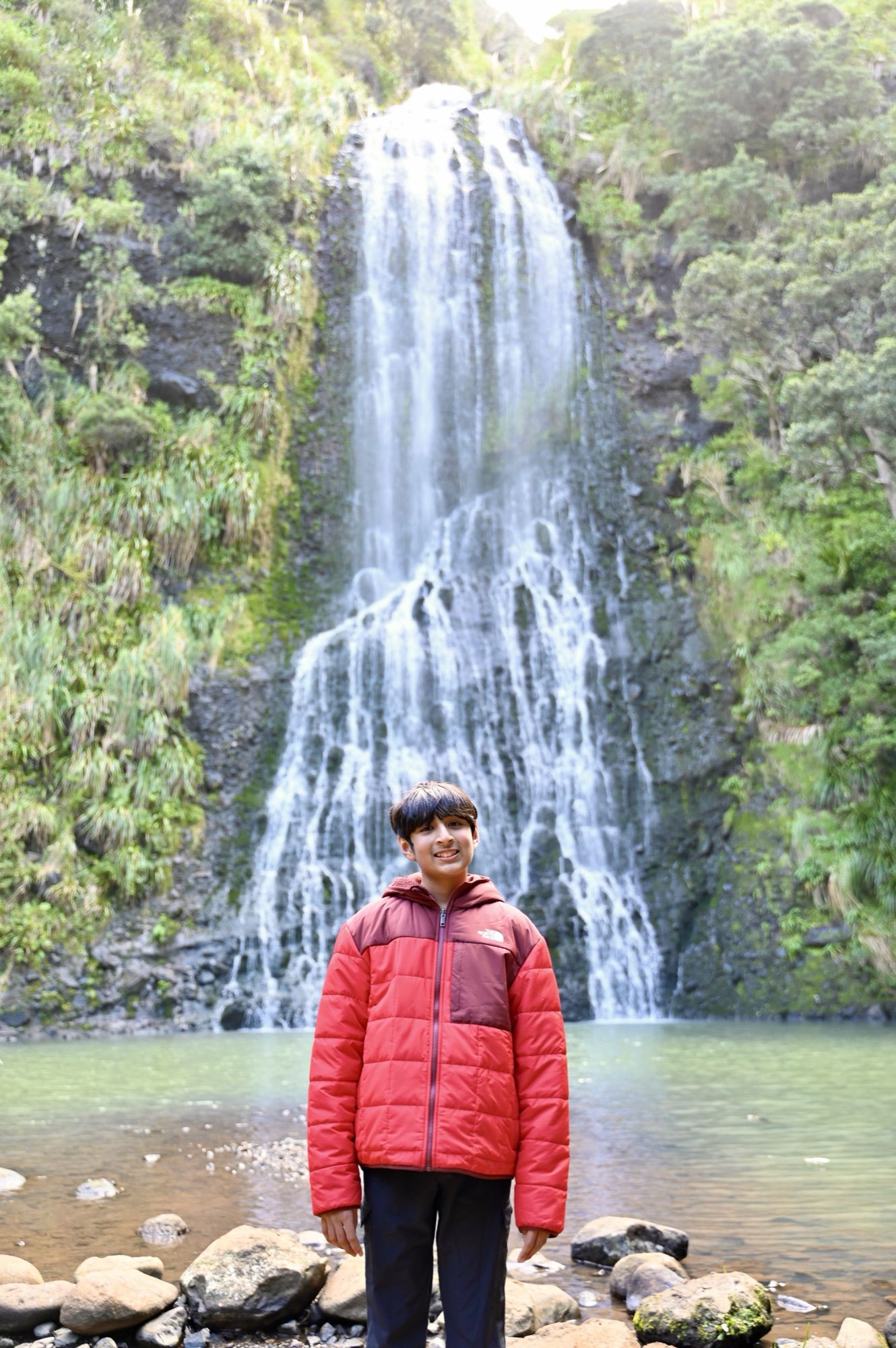 Our son smiling in front of Karekare Falls.