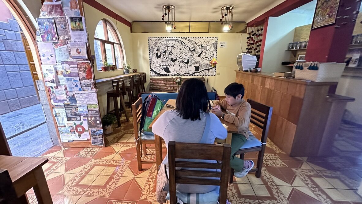 Woman and boy at a table inside El Café Feliz