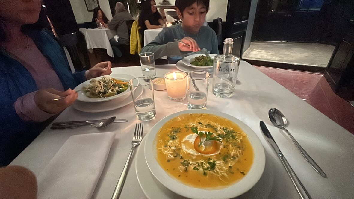 Bowls of soup and pasta on a candlelit table at El Albergue’s restaurant