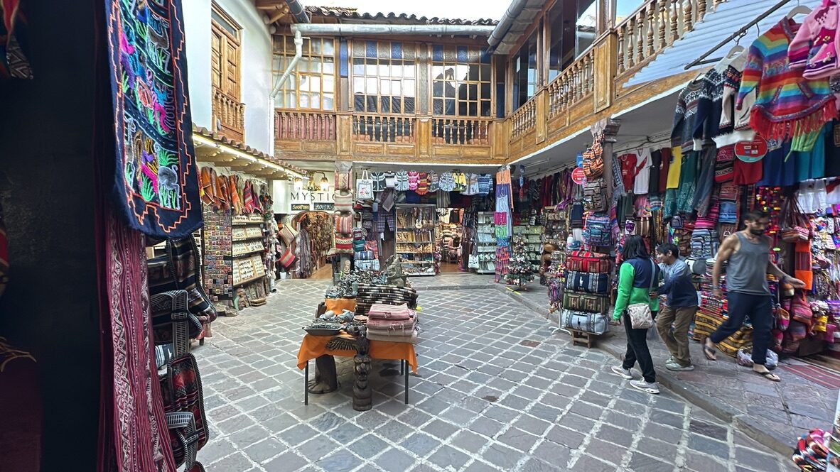 A courtyard of shops with balconies and hanging textiles in San Blas