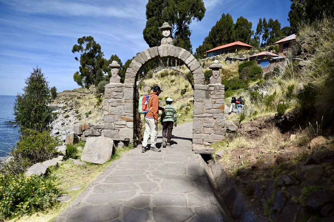 Boy and woman walking through a stone arch on the path
