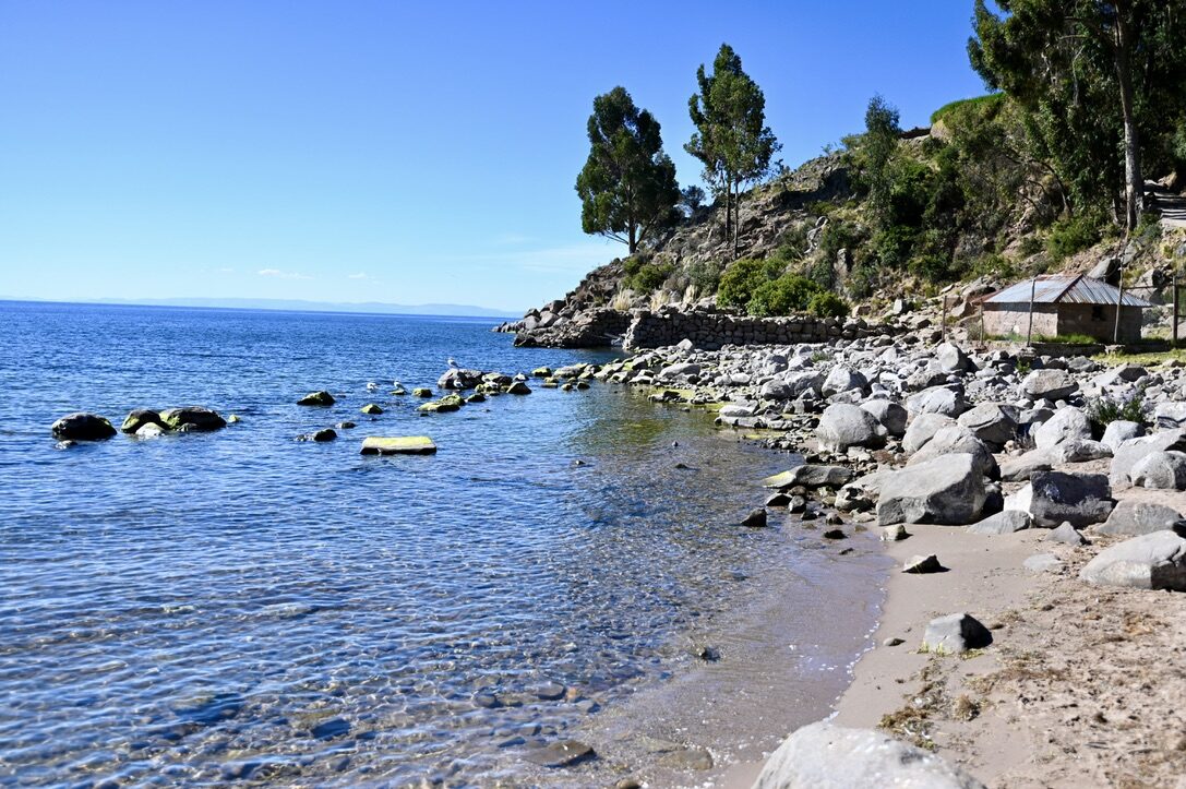A small rocky beach on the clear blue lake