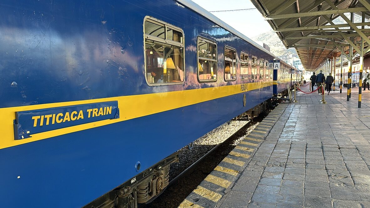 The blue and yellow Titicaca Train at the platform in Cusco